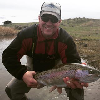 A client with a big rainbow caught on an Oregon private lake.